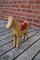 Horse of painted wood and with red saddle