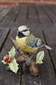 Bird on a rowanberry branch, cute figurine of 
biscuit